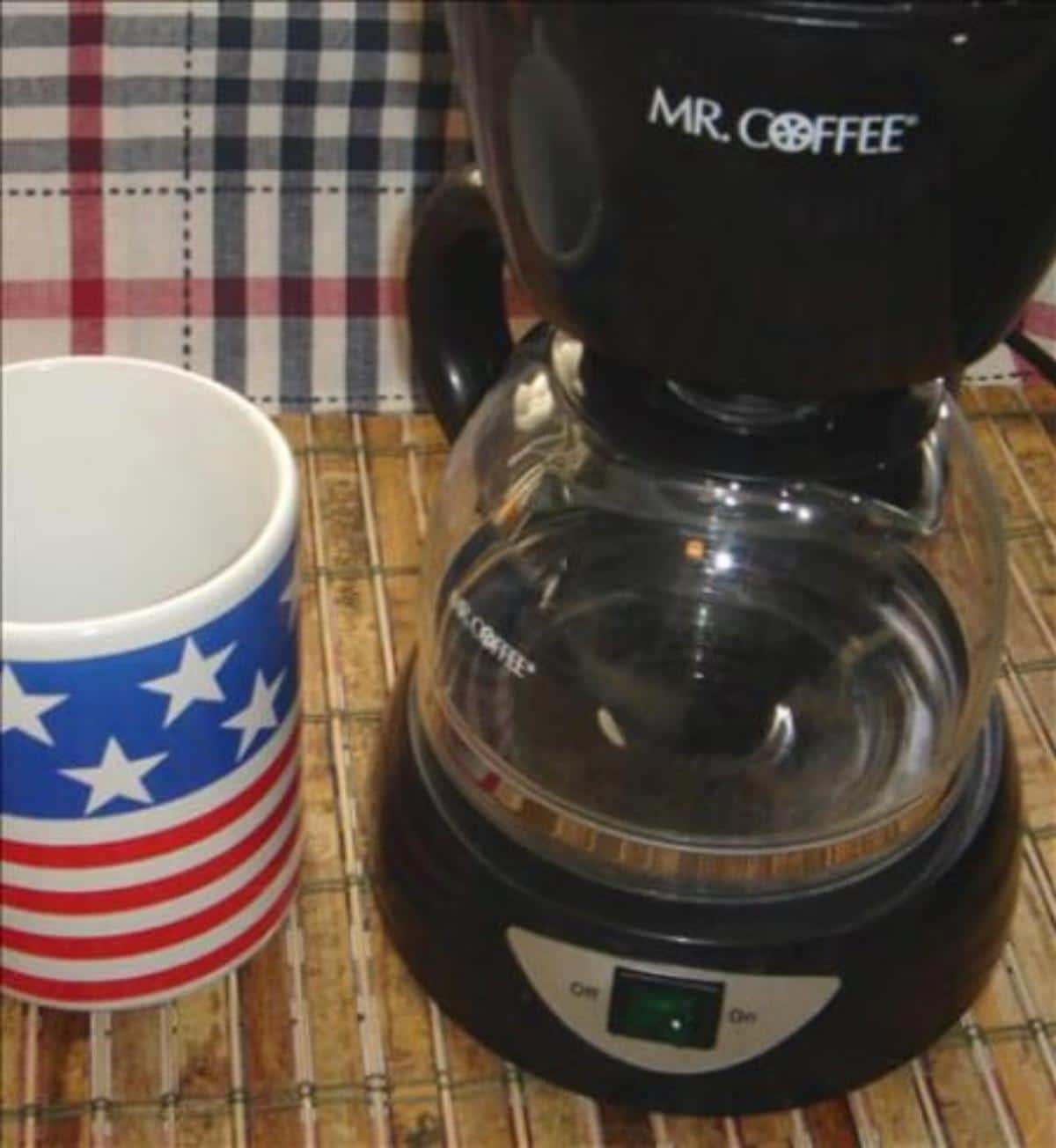 Automatic coffee maker with a cup.