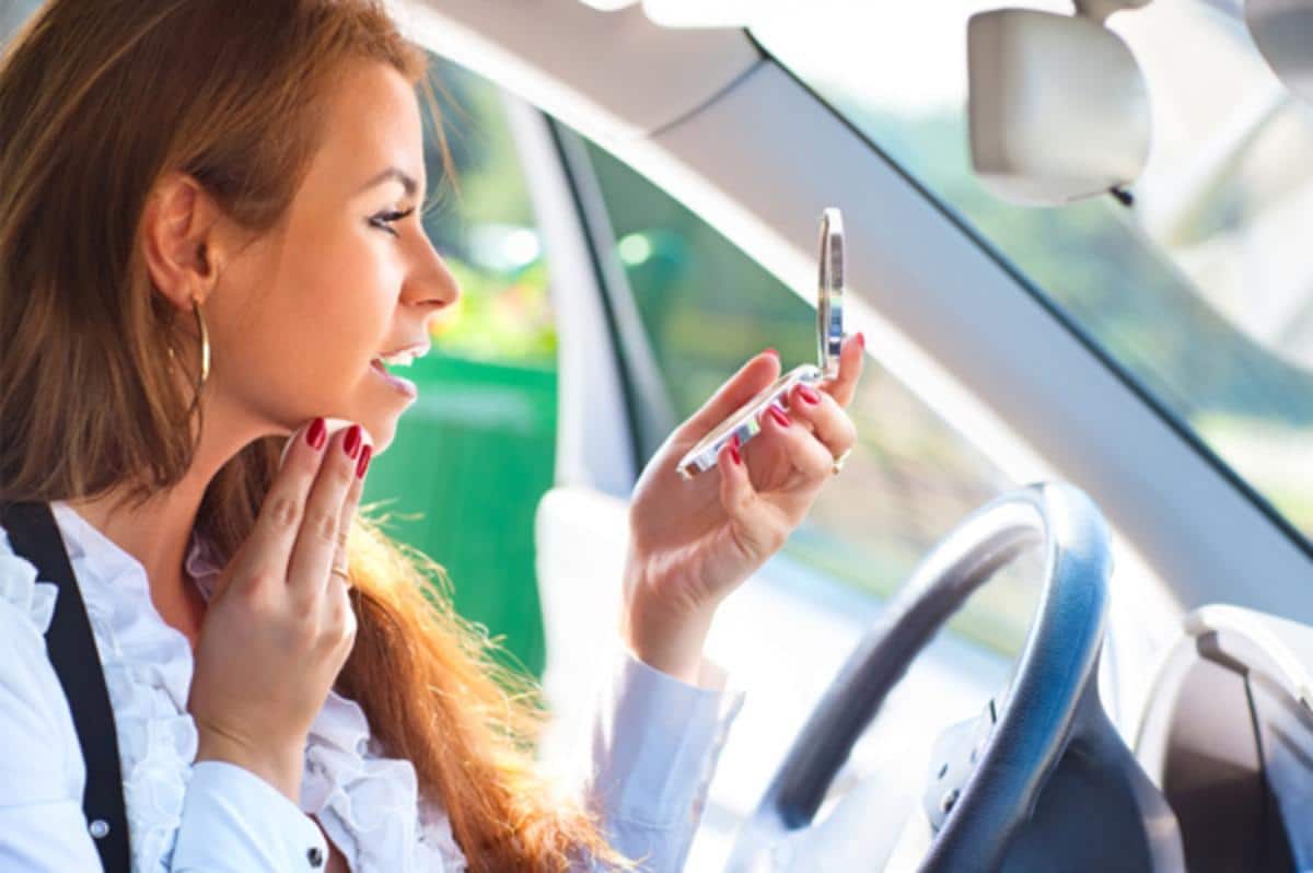 A woman Checks Makeup in the Car