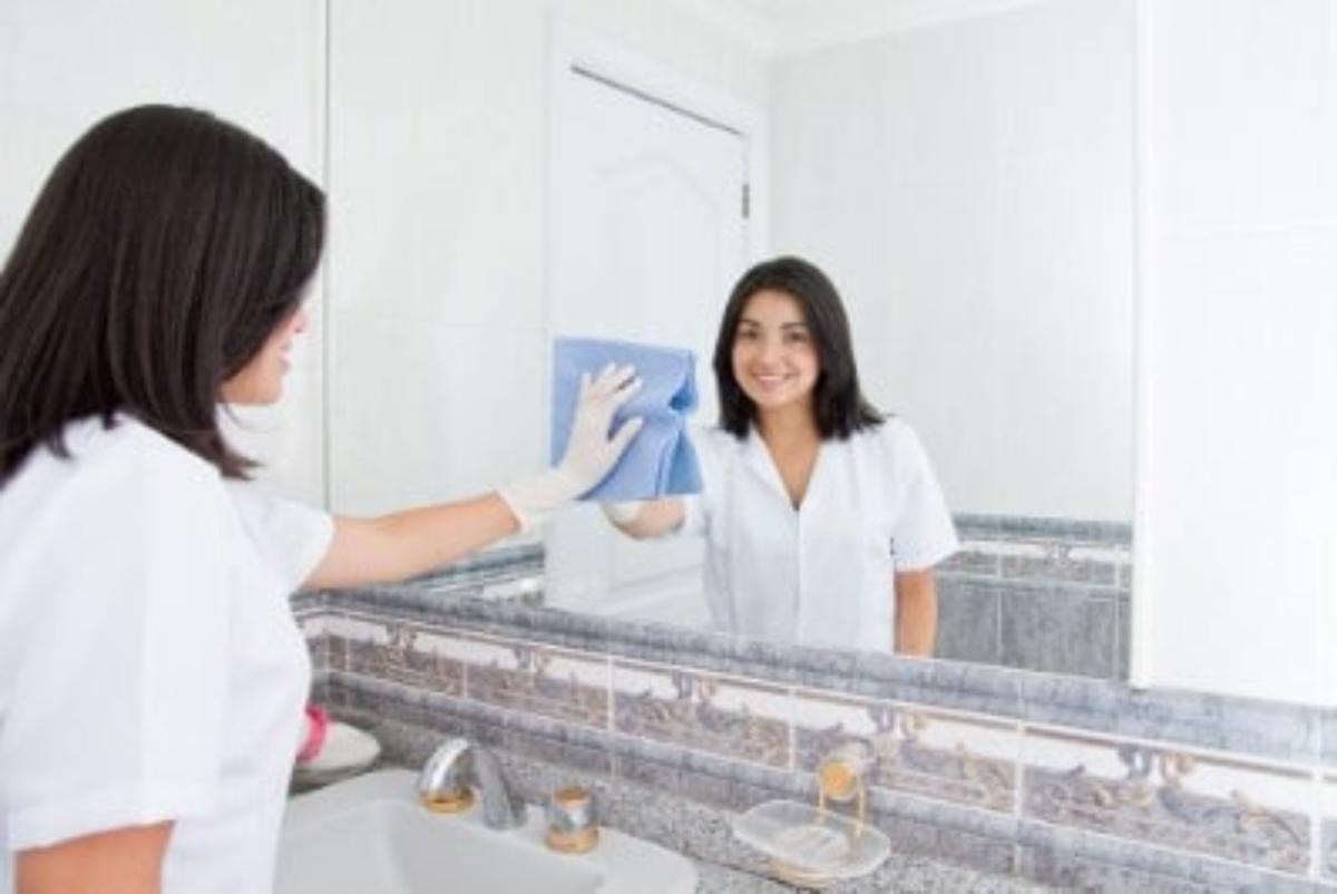 A woman is cleaning mirrors