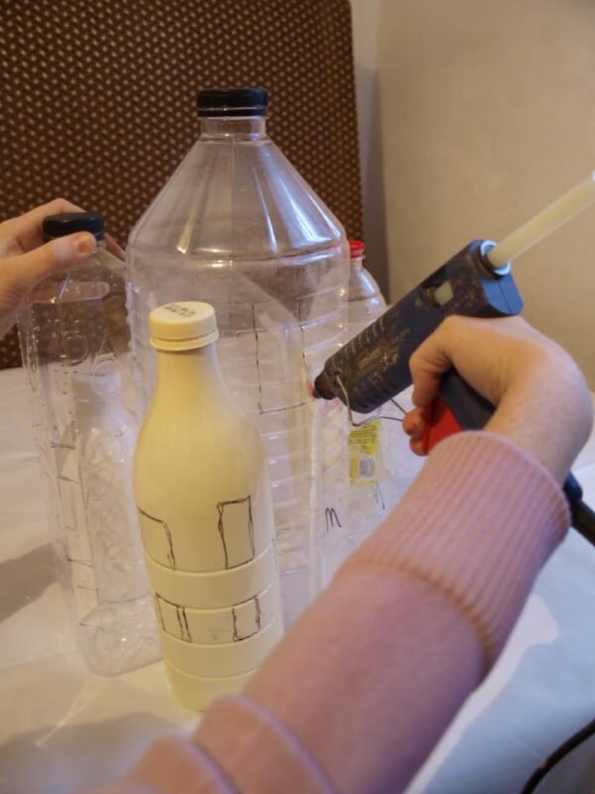 hot gluing plastic bottles of various sizes together