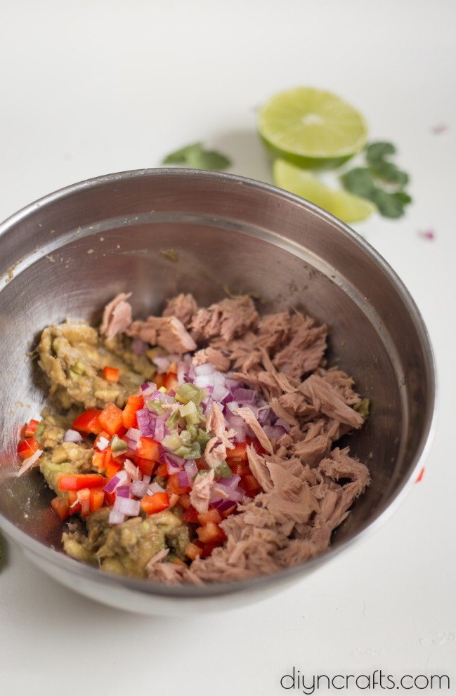 Mixing tuna with jalapeno and other ingredients.