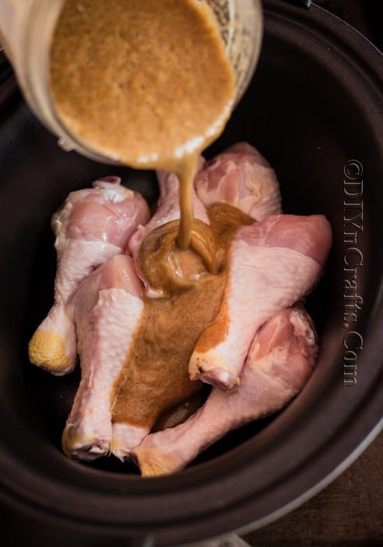 Adding sauce and chicken to crock pot.