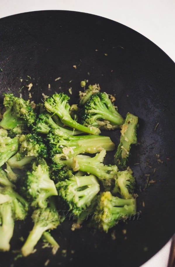 Cooking the broccoli before mixing chicken and sauce.