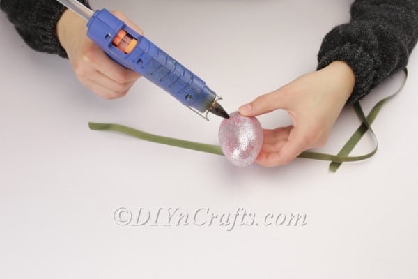 Attaching the ribbon to the middle of the plastic egg.