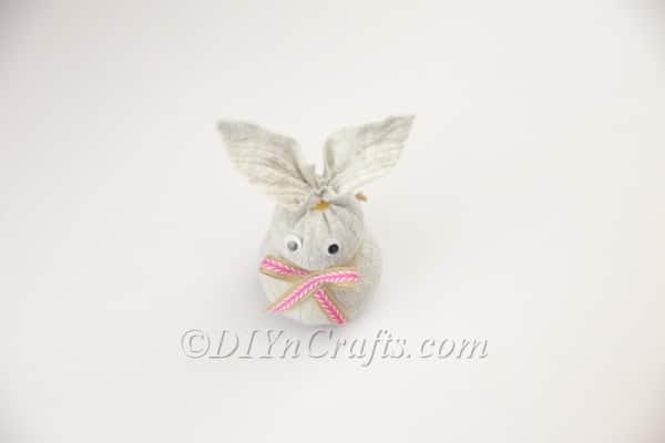 Attaching a cute bow to the bunny's neck.