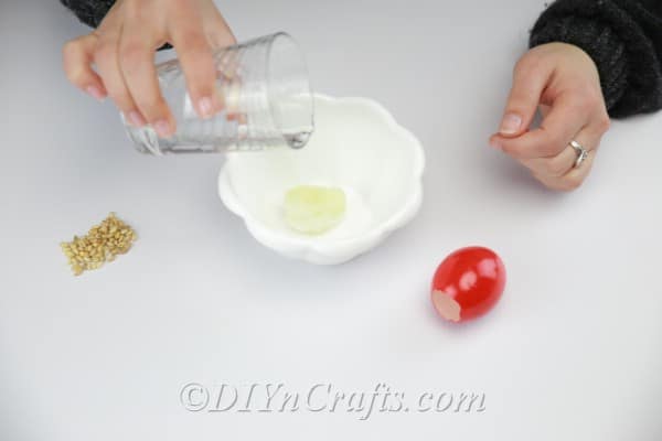 Filling the decorated empty eggshell with wet cotton.