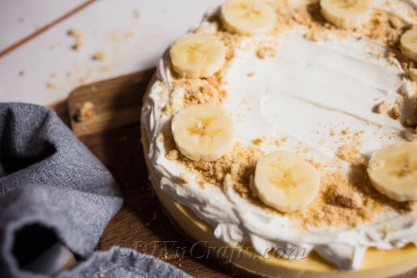 Homemade cheesecake topped with banana slices and cookie crumbs