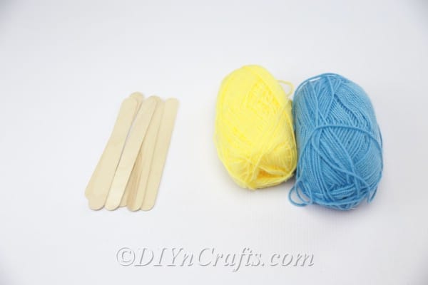 Popsicle sticks and yarn needed to make a coaster