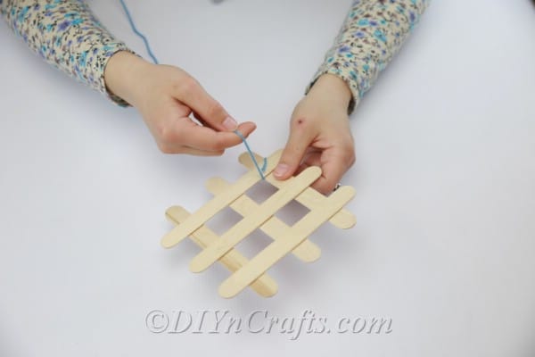 Wrap yarn in corners where popsicle sticks meet