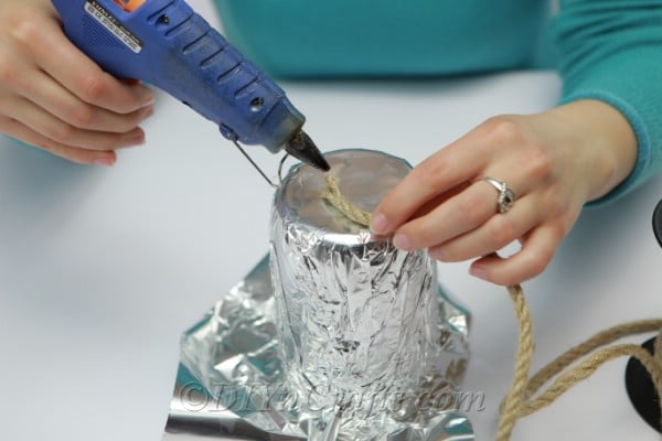 Adding glue to the bottom of a jar to hold the rope in place