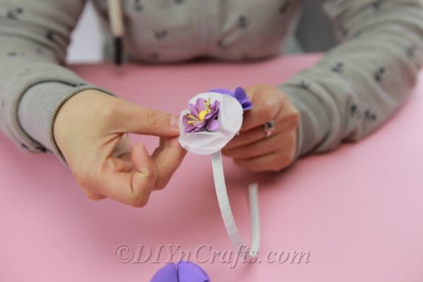 Gluing homemade fabric flowers onto a plastic headband