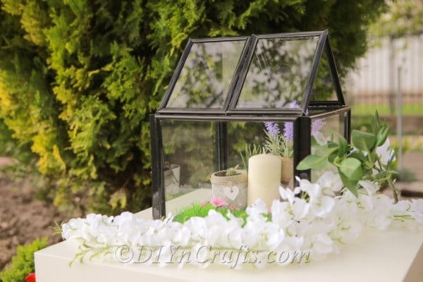 Mini greenhouse decorated with candles.