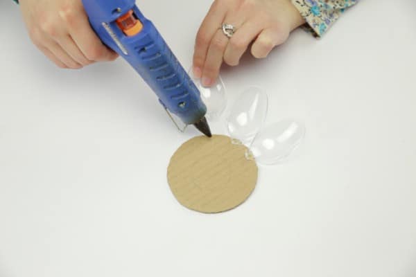 Gluing plastic spoons onto the cardboard circle