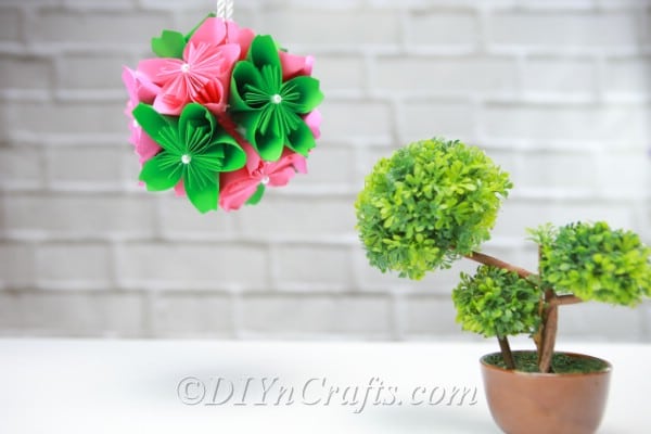 Paper flower ball hanging above a small plant