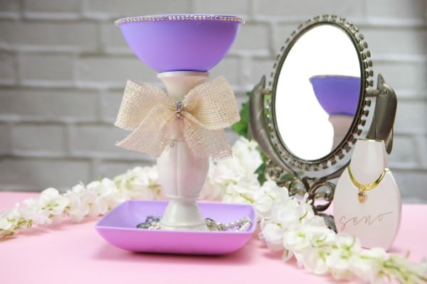 Jewelry holder sitting beside a mirror