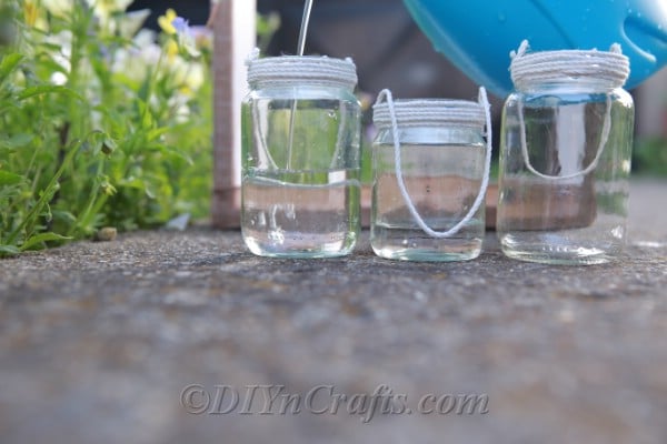 Three glass jars with thread around the tops