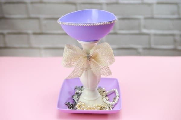 Purple jewelry stand with jewelry in the bottom plate