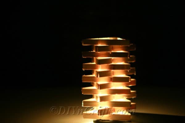 Clothespin lamp in a dark room.
