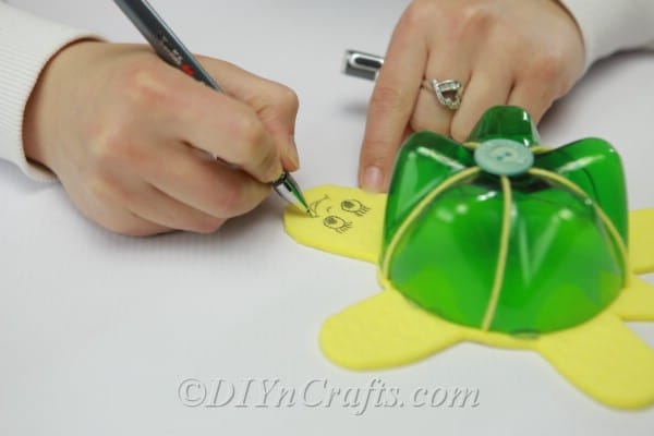 Drawing a face onto the yellow foam turtle