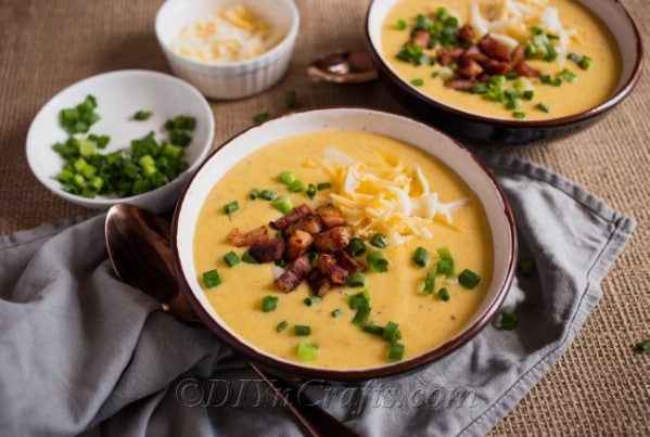 Cheesy Potato Soup being served with shredded cheddar, crumbled bacon and diced onions