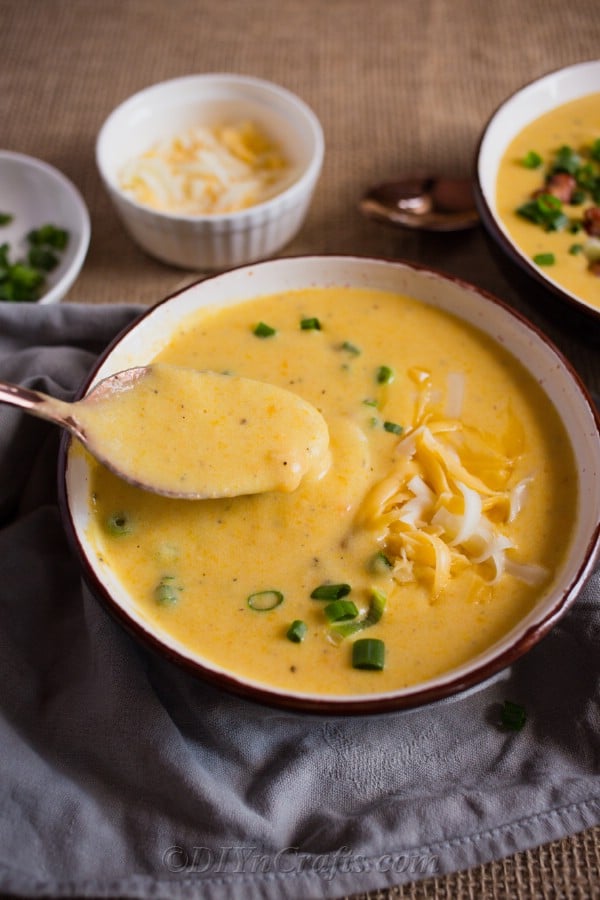 Stirring a bowl of cheesy potato soup