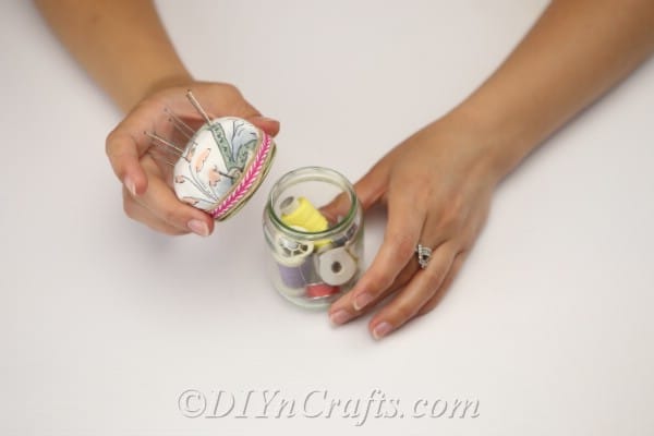 Place the lid on your pincushion jar after filling it with sewing supplies.