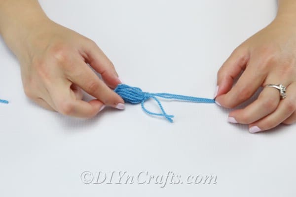 Tie a third string around the top of the tassel.