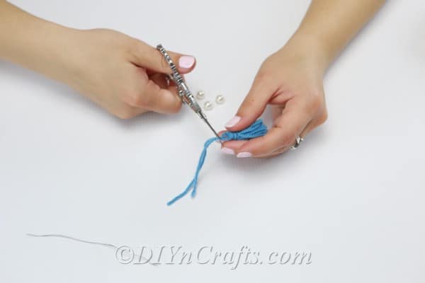 Cut off the two pieces of yarn sticking out of the top of the tassel.