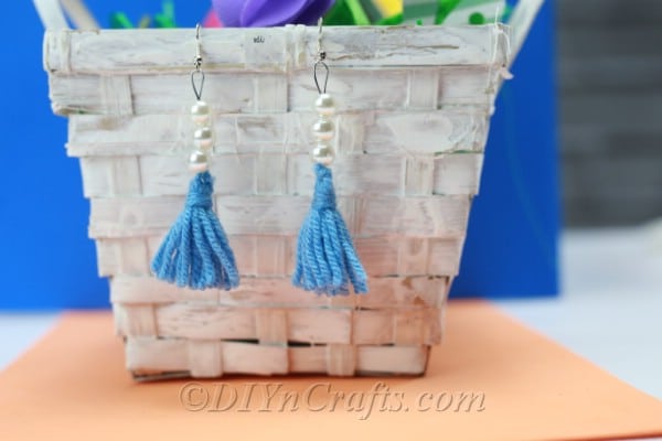 Tassel earrings hang displayed from a basket.