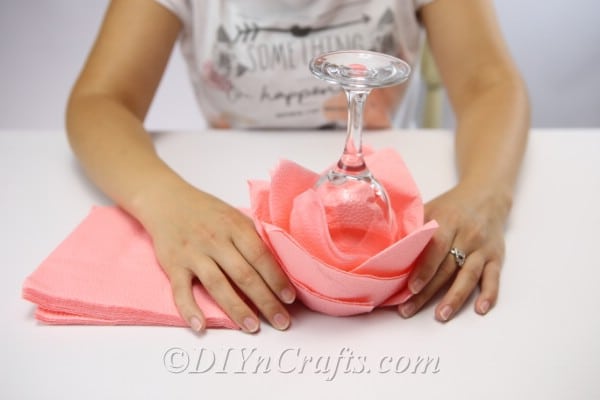 Removing the paper napkin from the glass for a folded napkin designed into a rose