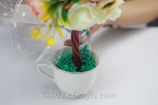 Pour decorative rocks into the cup.