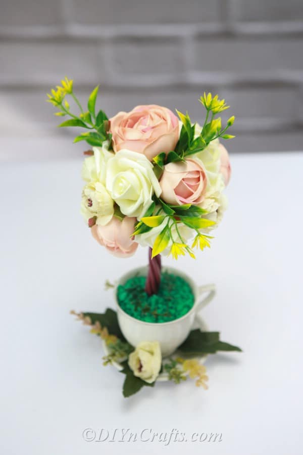 It is easy to make a flower arrangement topiary tree.