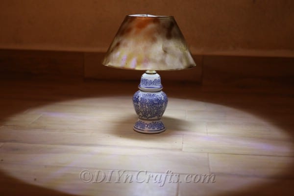 A solar lamp resting on the floor and shedding a soft glow.