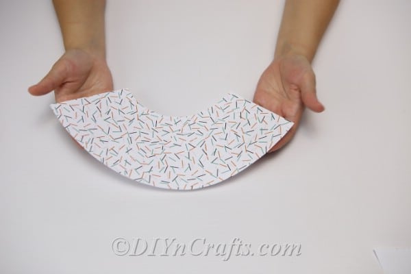 A woman measuring the craft paper shade template for the diy wine glass lantern