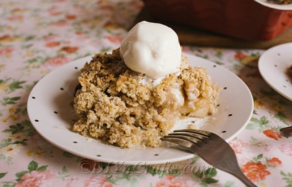 Up close picture of a prepared apple crumble recipe served with ice cream on a white plate