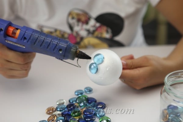 Continue gluing glass nuggets to the ball.