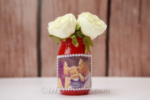 DIY vase featuring a family photo displayed with wooden wall in the background.
