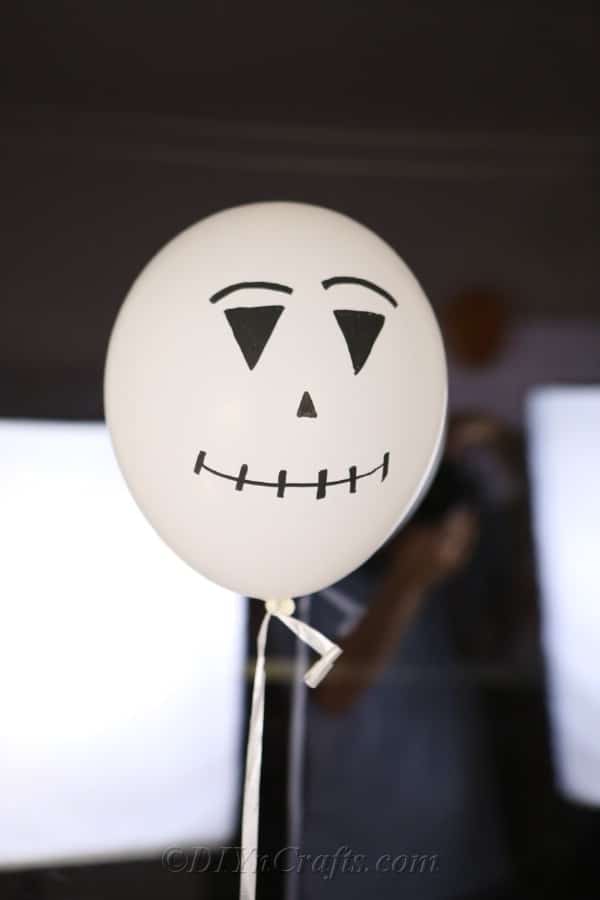 A white scarecrow or ghost halloween balloons design against a window