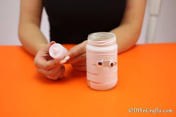 Adding the tealight to your mummy Halloween mason jar lights