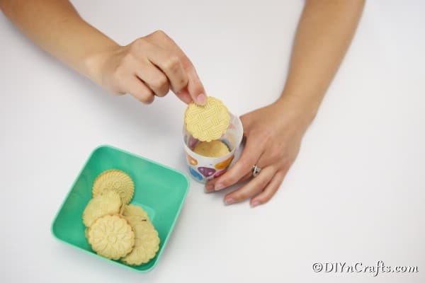Placing cookies inside a homemade cookie box from plastic party cup