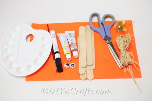Supplies for how to make a scarecrow out of popsicle sticks