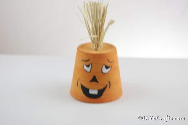 A finished pumpkin planter sitting on a white table