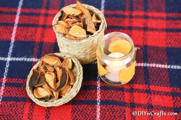 Overhead picture of fall leaf candle lanterns displayed on red plaid cloth