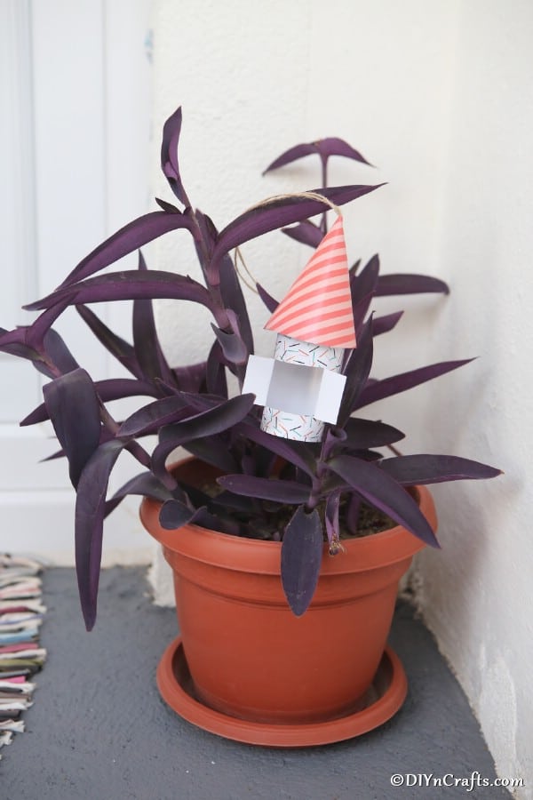 A paper gnome house sitting in a potted plant