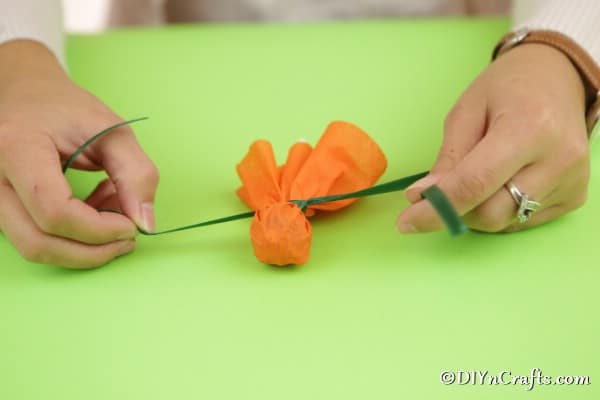Tying a ribbon around a lollipop to create a ghost