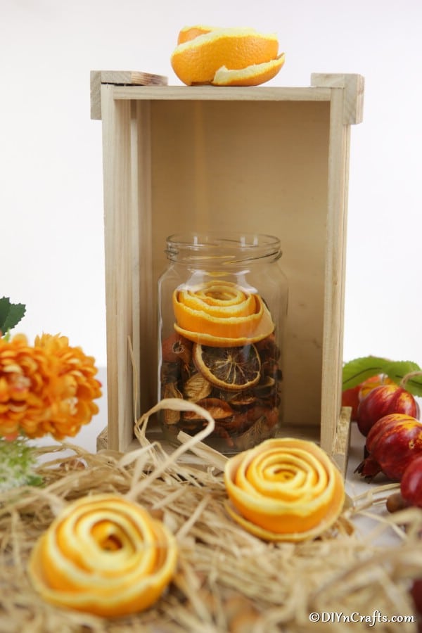 Orange flowers on a wooden box with decorative hay around the sides