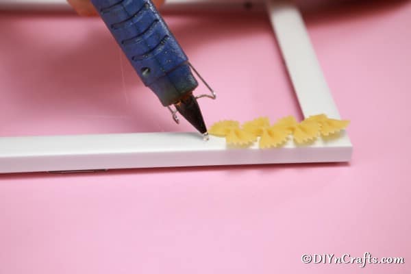 Gluing pasta to the outside of the picture frame