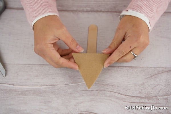Cutting a cardboard triangle out for making a pom pom tree
