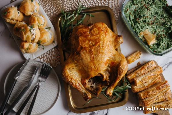 Overhead picture of a roasted rosemary chicken recipe with all of the sides on the table next to it