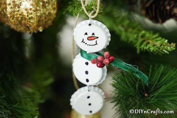 Snowman ornament hanging on a christmas tree